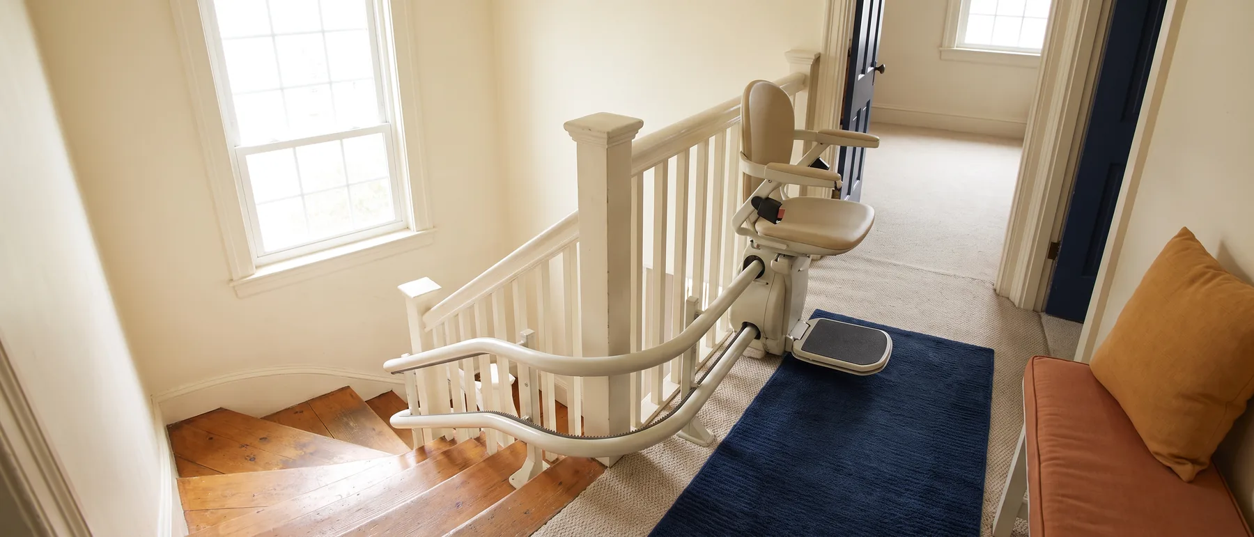 A curved stair lift rail following a staircase around a landing