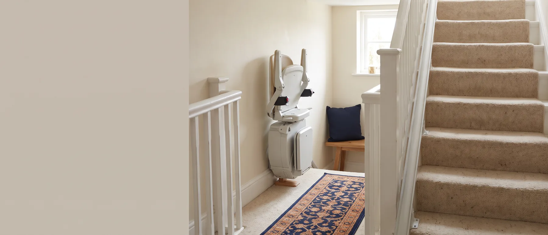 A compact stair lift folded flat against the wall of a narrow staircase